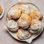 Traditional Ensaimada pastry from Mallorca dusted with powdered sugar on a wooden table
